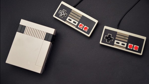 A retro gaming console placed on a black background. There are two controllers positioned next to the console.