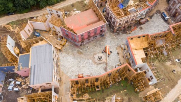 An aerial view of a large outdoor film set that features a large courtyard surrounded by multi-story buildings.