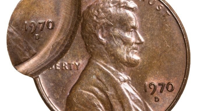 A worn penny featuring president Lincoln. The coin has a misprint error, where it features two dates in different places.