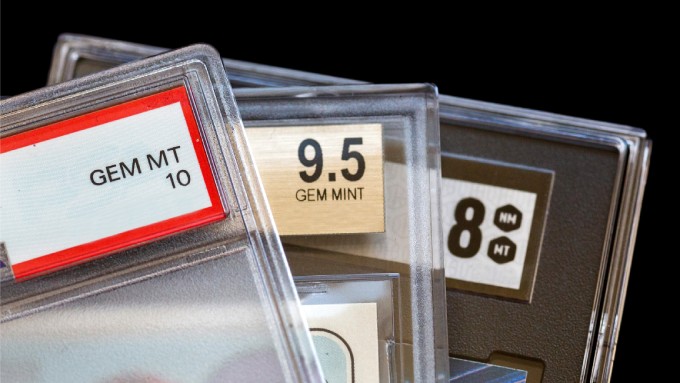 A close-up of protected cards graded. One is "GEM MT 10," another is "9.5 GEM M5" and the one in the back is "8 NM MT."
