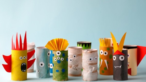 A blue background with several cardboard toilet paper rolls painted and decorated with different designs.